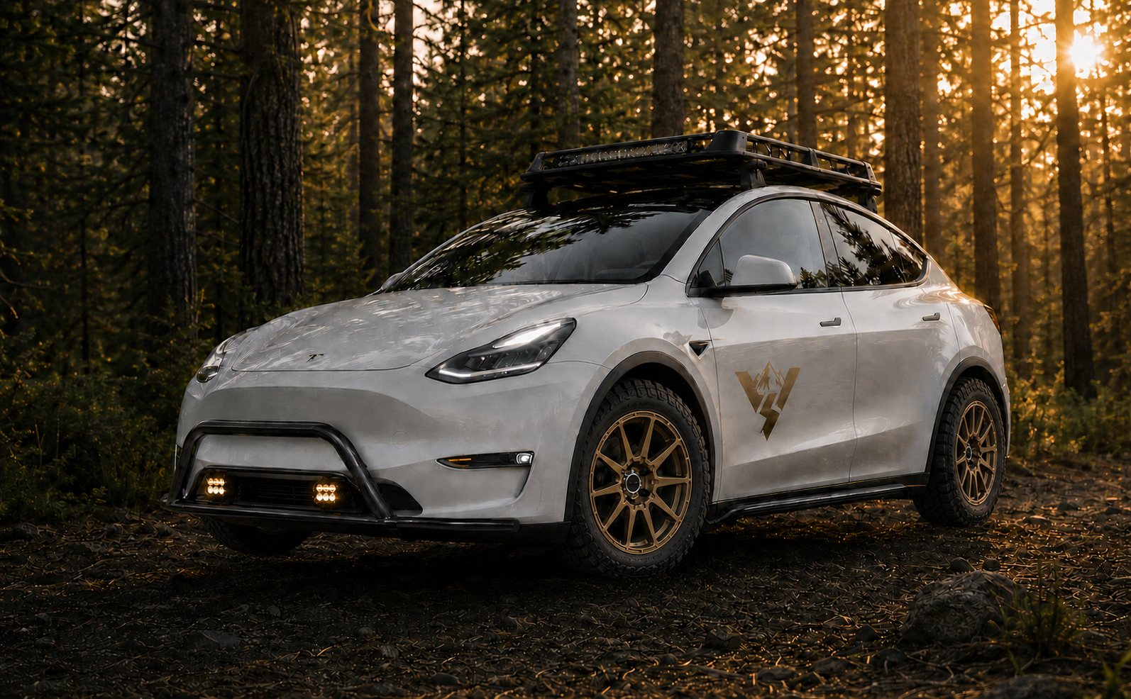 White adventure-ready Tesla Model Y with Bronze wheels in a forest
